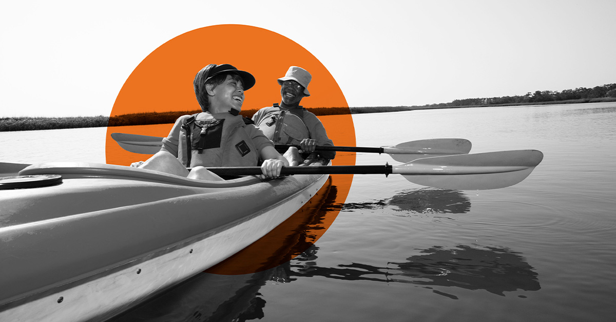 A couple kayaking on a still body of water.