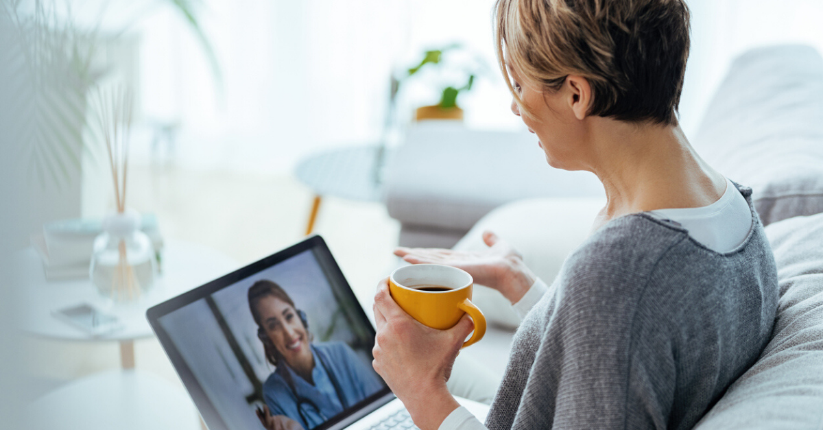 Woman sitting on the sofa while making video call over laptop with her doctor.