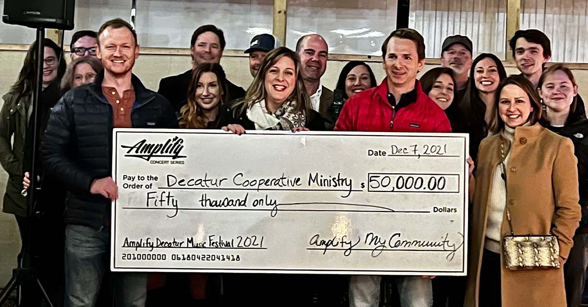Amplify handing Decatur Cooperative Ministry with a $50,000 check.