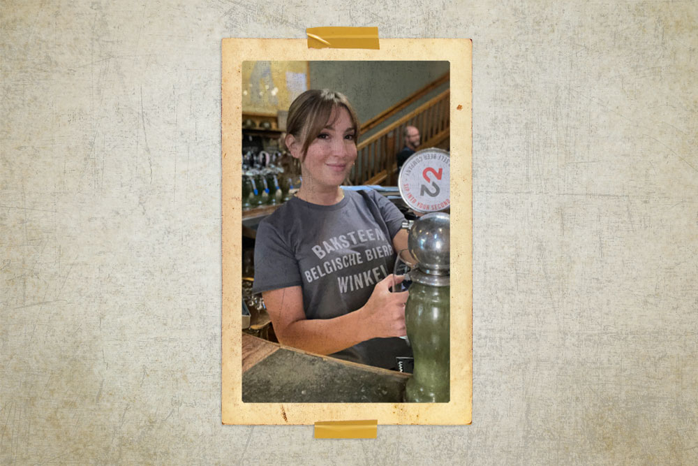 Christine Mahin with Lenz Marketing wearing a green Brick Store Pub t-shirt while pouring beer. 