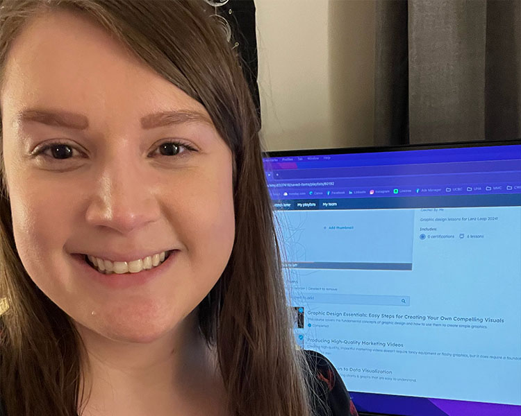 Marianne Danneman smiling in front of her computer monitor.